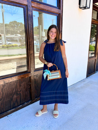 Navy maxi dress with side tie straps and white trimming.