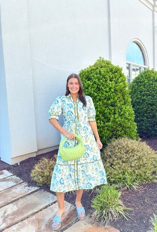 Short puff sleeve midi dress with a green and blue floral print. Dark green trimming with a built in belt.
